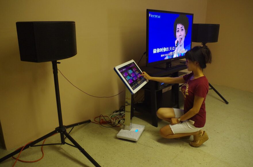 Zhuo Jia selects songs using the Karaoke machine in her restaurant. “Cooking and singing are two of my favorite things, and I would like to implement these two things in my restaurant,” Jia said. (Photo by Zhiming Zhang/WUFT News)