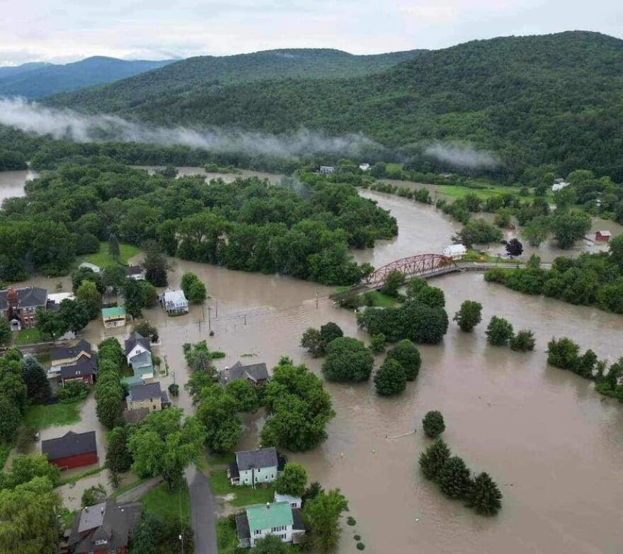 A drone shot of brown water flooding a park and neighborhood.