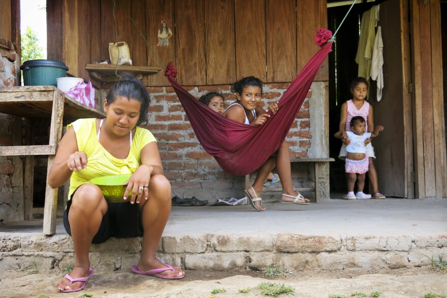 Ligda Bol, 19 years old, sits in front of her small farm. Her house, near the Brito River, is in the path of the proposed canal. Her family hasn't been told if she'll be forced to move, when a decision will be made or how she will be compensated for her farm.