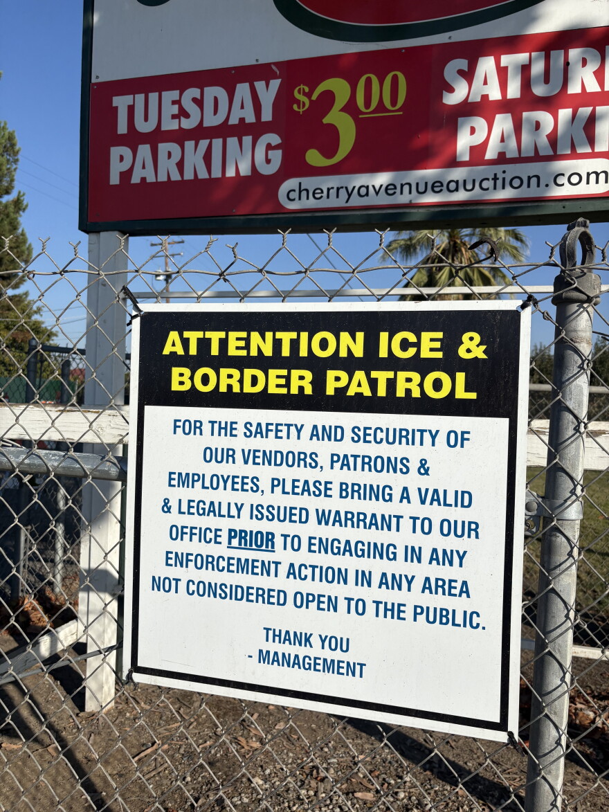A sign outside the Cherry Auction in Fresno, Calif., requests ICE and U.S. Border Patrol agents to check in before proceeding with enforcement activities. The sign has been in place since 2025.