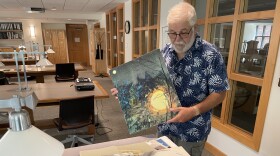 Librarian Emeritus Bill Ross shows off images of aliens from Betty and Barney Hill's collection at the University of New Hampshire Library.