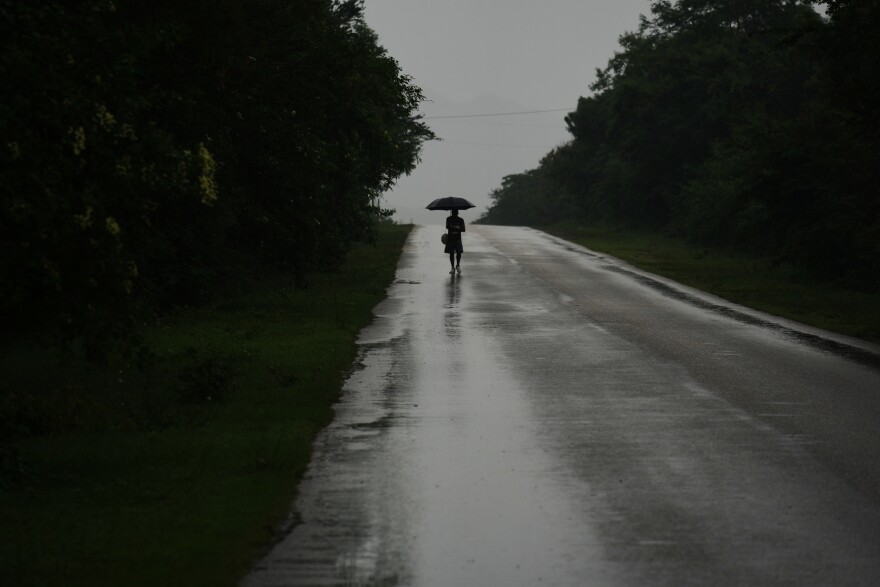 A man walks in the rain before the arrival of Hurricane Melissa in Canizo, a community in Santiago de Cuba, Tuesday, Oct. 28, 2025.