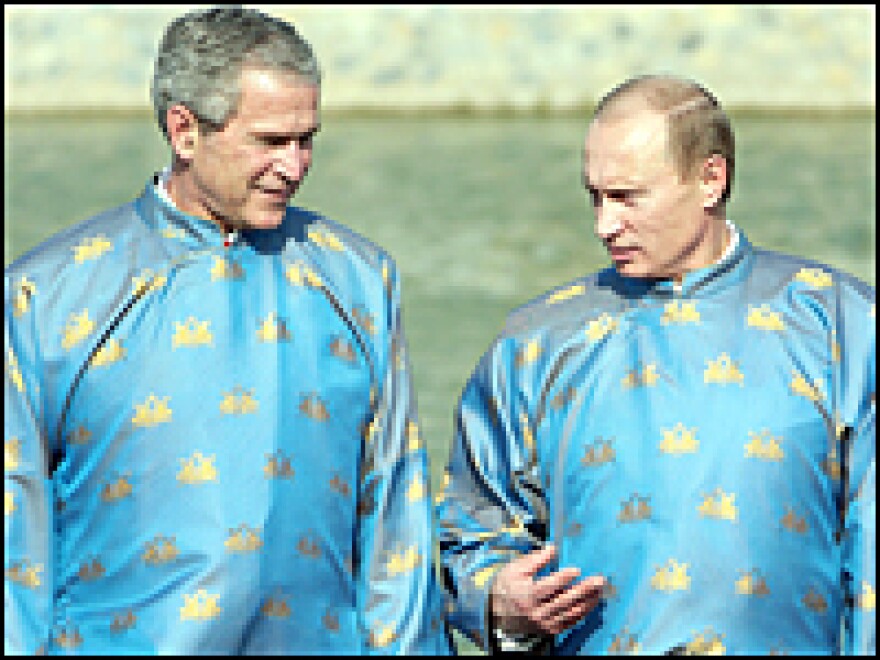 President George Bush (left) and Russian President Vladimir Putin wear 'ao dai' Vietnamese tunics at the APEC summit in Vietnam, Nov. 19, 2006.