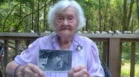 June Whitehurst, wearing her silver U.S. Marines insignia pin, talks about her service as one of the nation’s first enlisted women Marines on active duty during World War II. She started working on her scrapbook in the early 1940s and has preserved handwritten letters, wartime documents and photos in its aged pages. (Brittany Valencic/WUFT News)