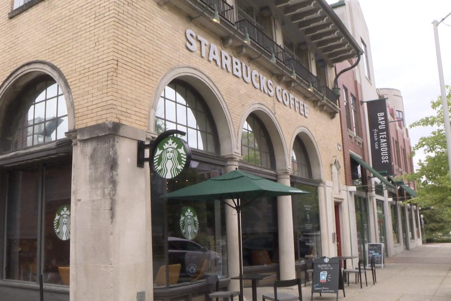 Tan brick building with the Starbucks logo on the side of the building, with Starbucks Coffee written in white lettering at the top.  