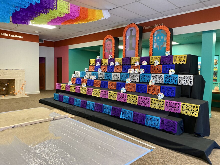 Día de Muertos altar being built inside the community gallery.