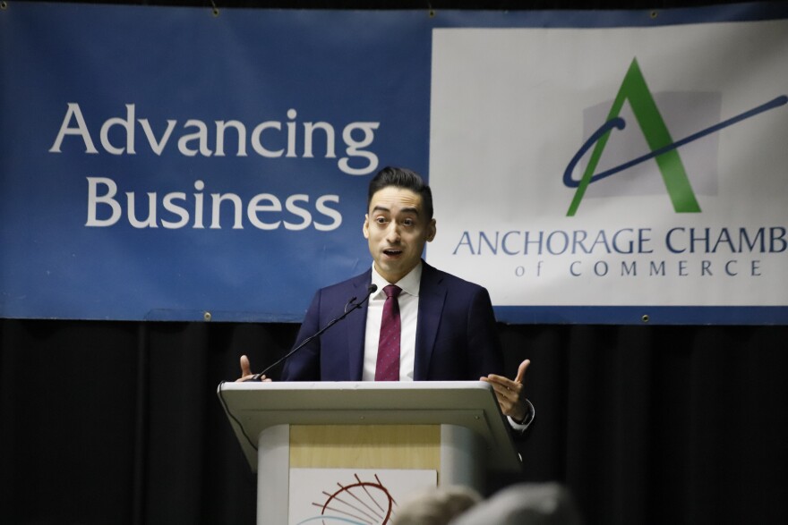 a man in a blue suit speaks at a podium