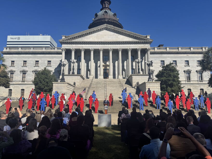 Red and blue silhouettes representing the 40 women and men who died from domestic violence are displayed during the 2026 Silent Witness Ceremony on the Statehouse grounds in Columbia.