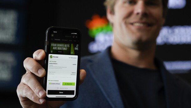 Fox Sports broadcaster Greg Olsen, who placed the first ceremonial bet in North Carolina, shows his receipt during a DraftKings event celebrating the launch of mobile and online sports wagering across the state at the NASCAR Hall of Fame, March 11, 2024, in Charlotte, N.C. The North Carolina official tasked with carrying out the state's new legalized sports wagering law said Wednesday, March 27, that betting from smartphones and desktops got off to a “strong start.” 