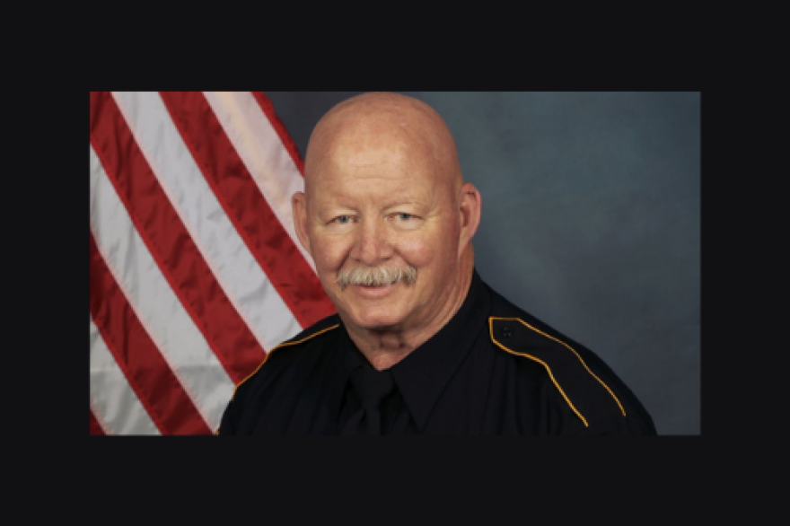 Mike Vance in uniform with an American flag in the background.