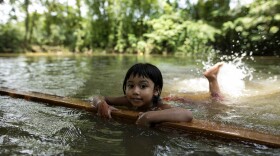 A child learns to swim in a pond in a rural area of Bangladesh.