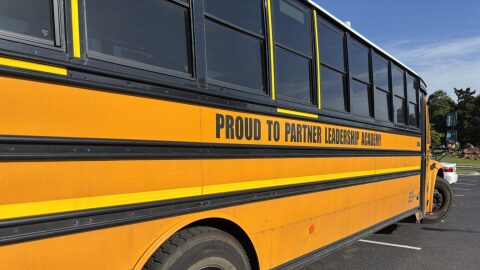 A school bus from Proud to Partner Leadership Academy is parked in front of the Oklahoma History Center in Oklahoma City on April 29 while a termination hearing for the school goes on inside.