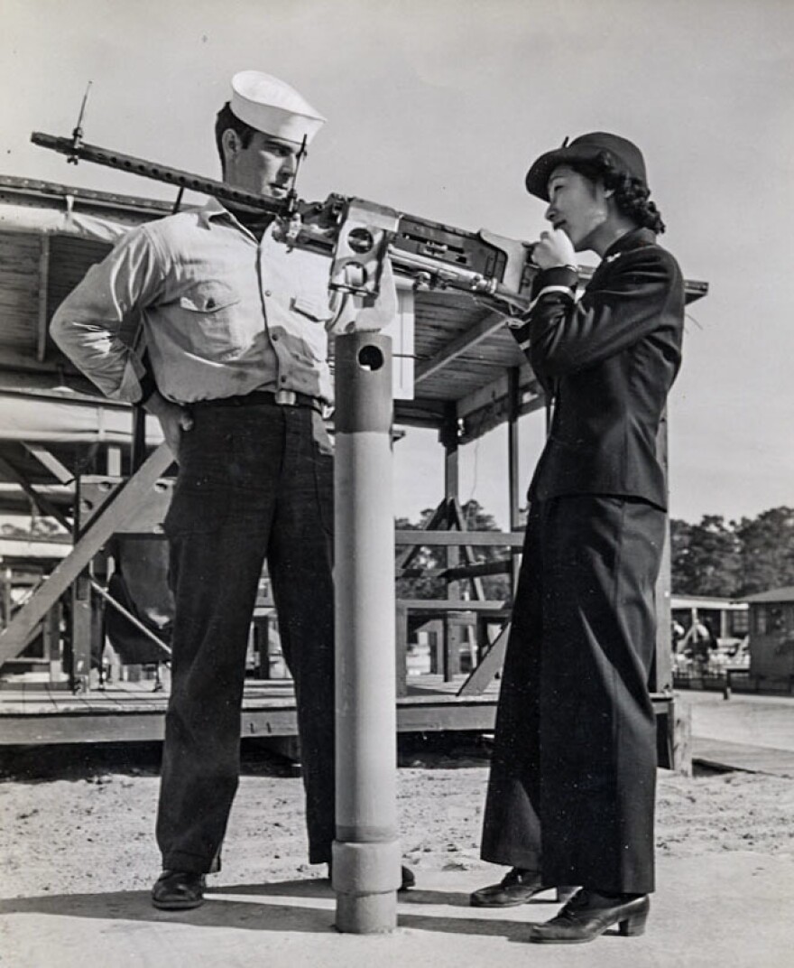 In 1943, Susan Ahn Cuddy is seen at the Pensacola U.S. Naval Air Station in Florida, instructing a sailor on how to fire a .50-caliber machine gun.