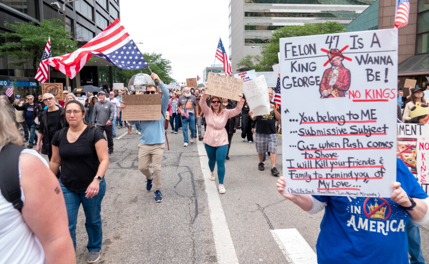 People protesting march with signs.