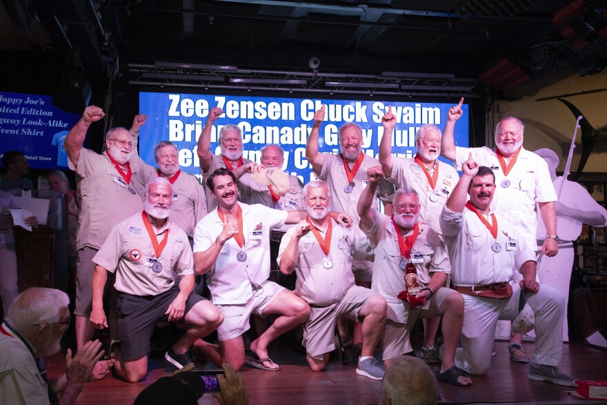 Twelve finalists from a field of more than sixty competitors, enjoy a moment of triumph at the conclusion of the opening round of the 45th annual “Papa” Hemingway Look-Alike Contest, Thursday, July 23, 2026, at Sloppy Joe’s Bar in Key West, Fla. The competition, a signature event of a six-day Hemingway Days festival, continues with a second round on Friday, July 24, and with the final round on July 25. Events continue through Sunday.