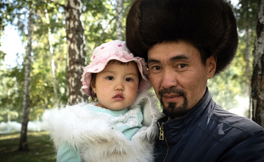 A Kyrgyz performer at the games poses with his daughter.