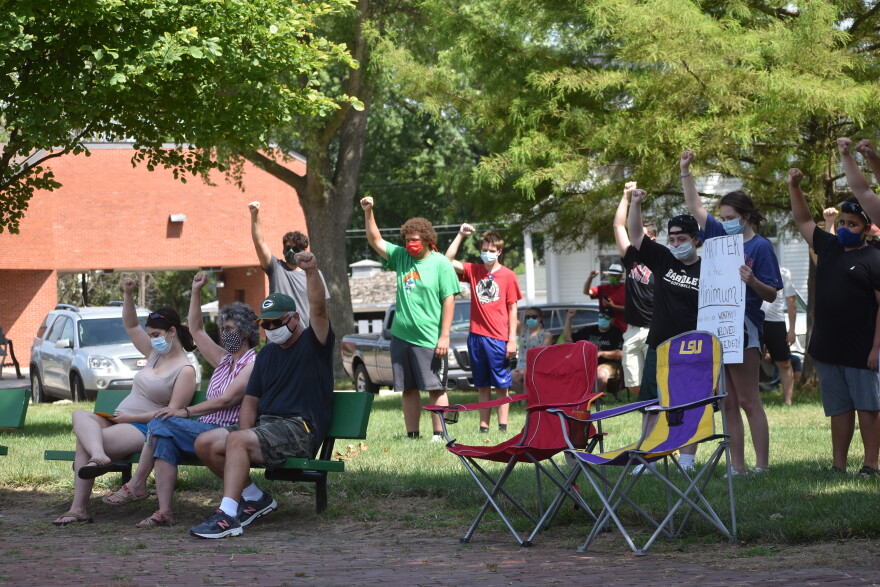 Attendees of the Elmwood BLM protest hold up fists in remembrance of John Lewis, a Georgia congressman and civil rights activist who died Friday at age 80.