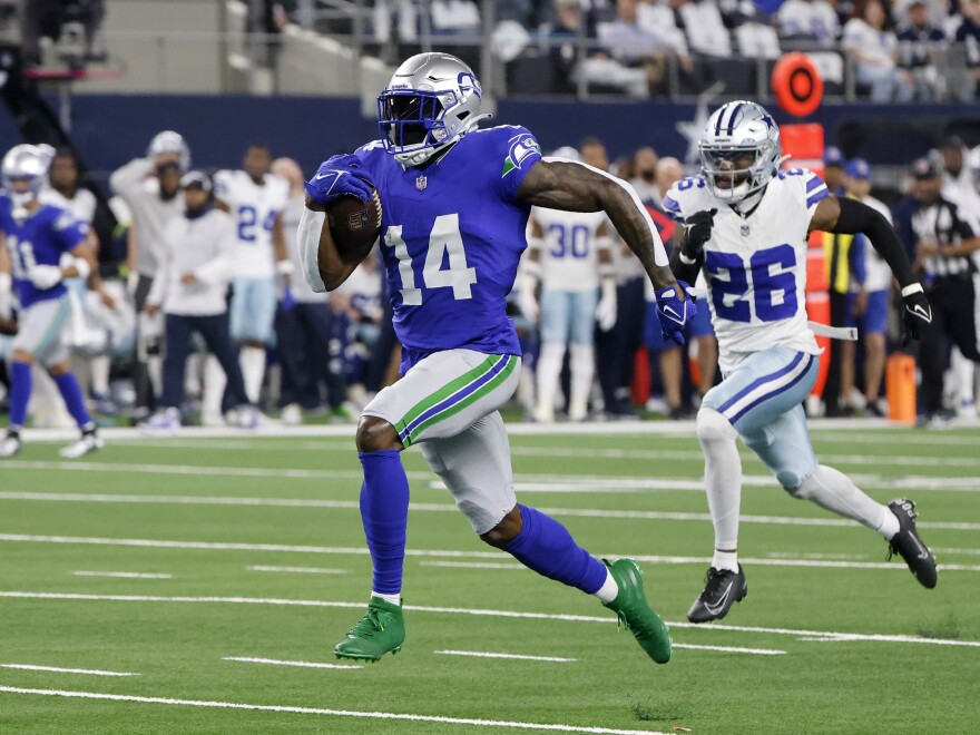 Seattle Seahawks wide receiver DK Metcalf (14) sprints to the end zone to score a touchdown as Dallas Cowboys cornerback DaRon Bland (26) gives chase in the first half of an NFL football game in Arlington, Texas, Thursday, Nov. 30, 2023.