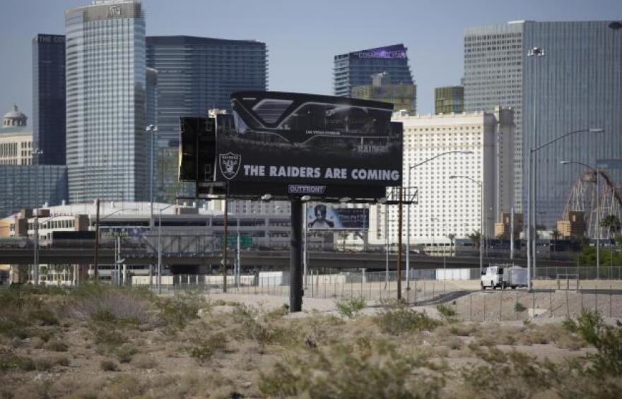 In this May 11, 2017, file photo, a sign advertises the Raiders football team near a site for the team's stadium in Las Vegas.