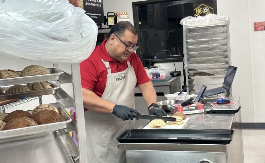 Pastry chef Alex Peña cuts into freshly baked conchas.