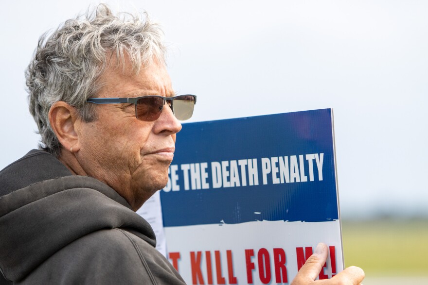 A protester stands outside of the Florida State Prison in Raiford, Fla. April 12, 2023. A group from Our Lady of Lourdes church stood outside the prison holding signs that opposed the execution of Louis Gaskin. Gaskin nicknamed the ‘ninja killer’ shot and killed Robert and Georgette Sturmfels Dec. 20, 1989. This is Florida’s 100th execution since the reinstatement of the death penalty in 1976. (Rae Riiska/WUFT News)