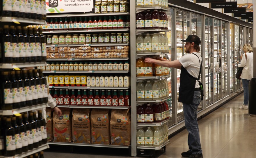 A Whole Foods employee works on the store's opening day on Wednesday, April 12, 2023.