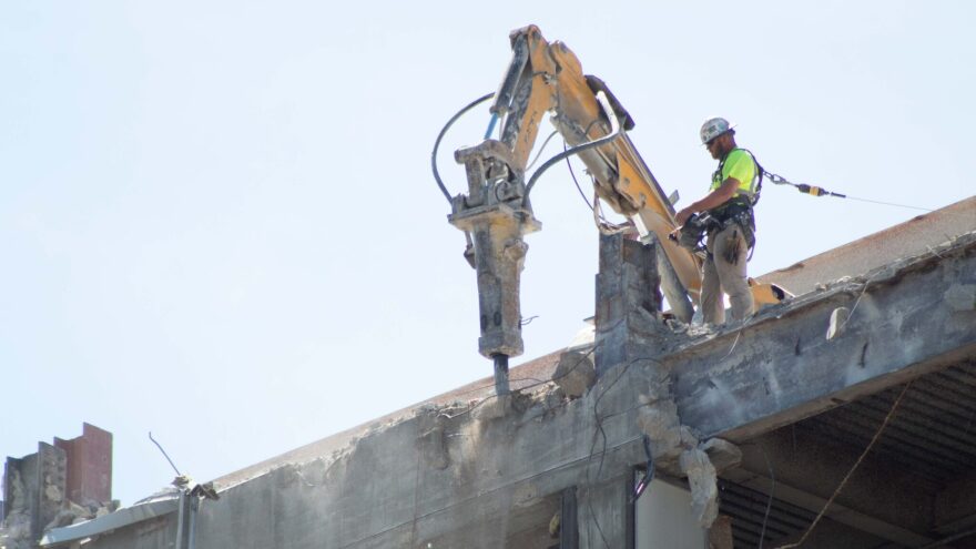 The Kansas Legislature passed a bill raising the ceiling for no-bid county construction projects and rejected a companion proposal repealing construction worker protections. A construction worker appears on Aug. 17, 2023, demolishing the former Docking State Office Building in downtown Topeka, Kansas.
