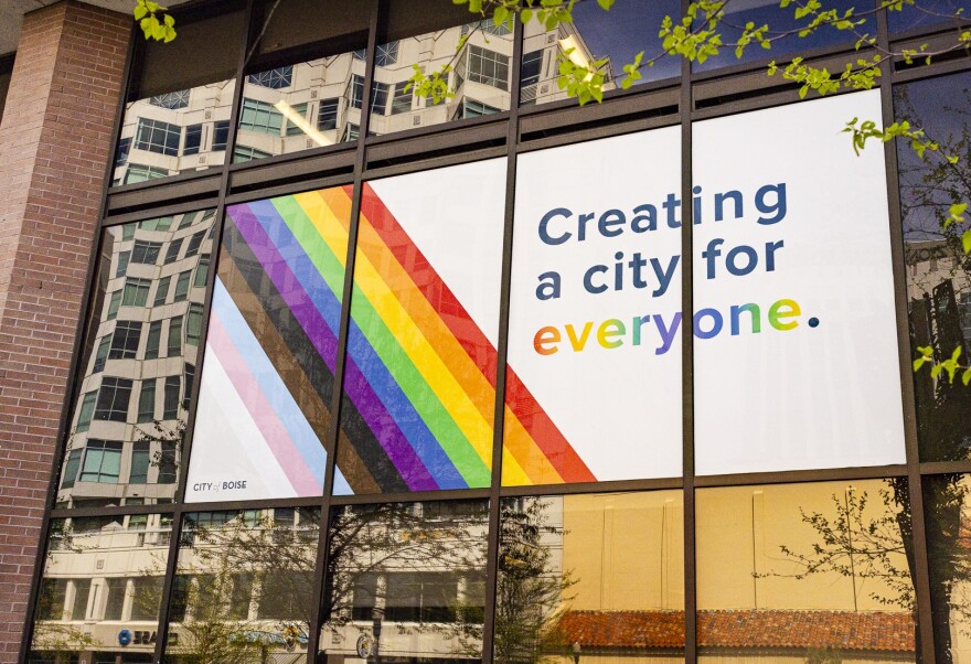 A picture of a banner displayed on the outside facade of City Hall shows the LGBTQ colors on a white background with the words "Creating a city for everyone"