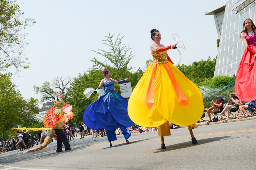 Dancers on stilts dressed as butterflies dance in the Parade the Circle.