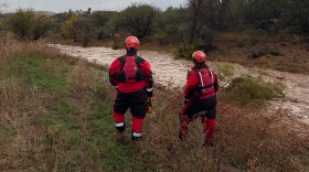 Two first responders stand next to Big Bug Creek in the Cordes Lakes community on Tue, Nov. 18, 2025. It was the site of a flash flood that carried off a car and an elderly man who was driving after 2–3 inches of rain fell over the area during the course of two days.