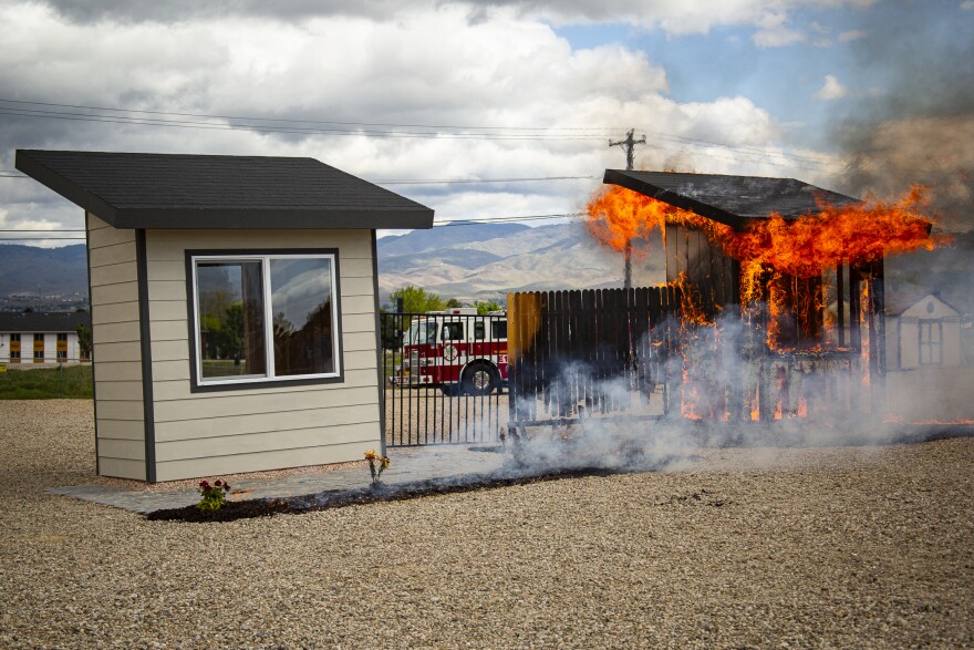 During a recent demonstration burn at the National Interagency Fire Center, one poorly prepared shed-like structure burns to the ground while the other escapes undamaged. 