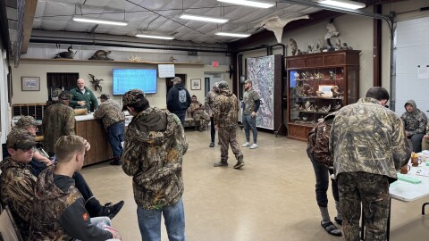A group of hunters, all dressed in camouflage, waits in a Missouri Department of Conservation office to hear if they've been granted access to hunt ducks.
