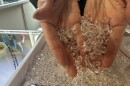A woman's hand scoops up a tray full of diamond looking stones that are actually Herkimer Diamond quartz.