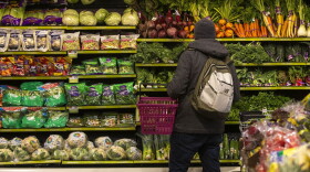 A customer peruses the produce at Roche Bros. in West Roxbury. (Jesse Costa/WBUR)