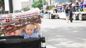 A baby watches the parade