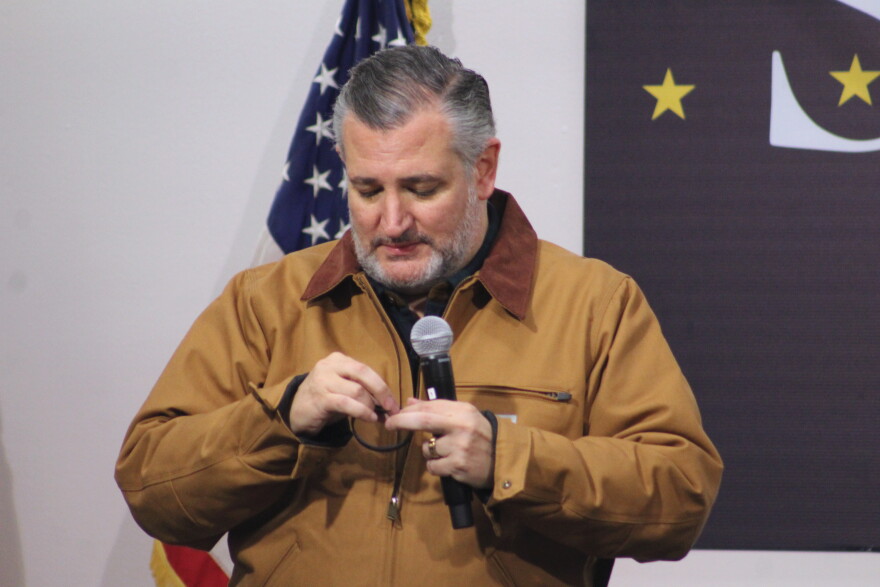Republican Sen. Ted Cruz reads a wristband to attendees at a political rally on Saturday, Oct. 17, 2026 in Kenai, Alaska. The wristband displays how incument Sen. Dan Sullivan's name will appear on Alaska's 2026 General Election ballot. Another candidate named Dan Sullivan is running for the same seat.