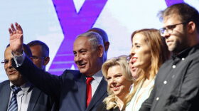 Israeli Prime Minister Benjamin Netanyahu (second from left) and his wife Sara (center) react during a gathering by Likud party members and activists at the Tel Aviv Convention Center on Aug. 9, 2017 in a mass show of support for the prime minister, who is facing a string of corruption investigations. (Jack Guez/AFP/Getty Images)