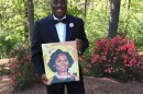 Malcolm Graham holds a portrait of his sister, Cynthia Hurd.