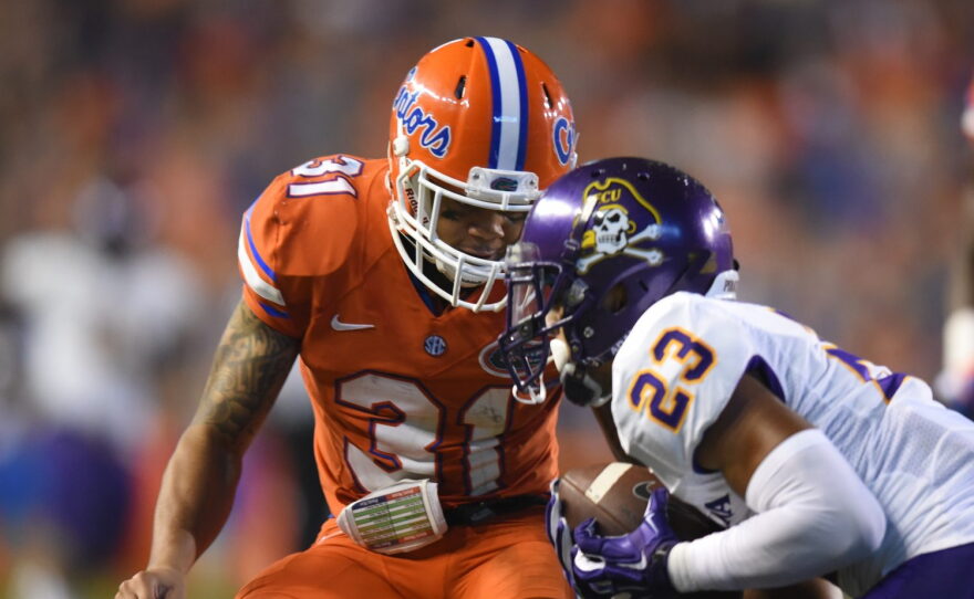 After completing a catch, East Carolina wide receiver Quay Johnson (23) he is met by Florida defensive back Jalen Tabor (31).
