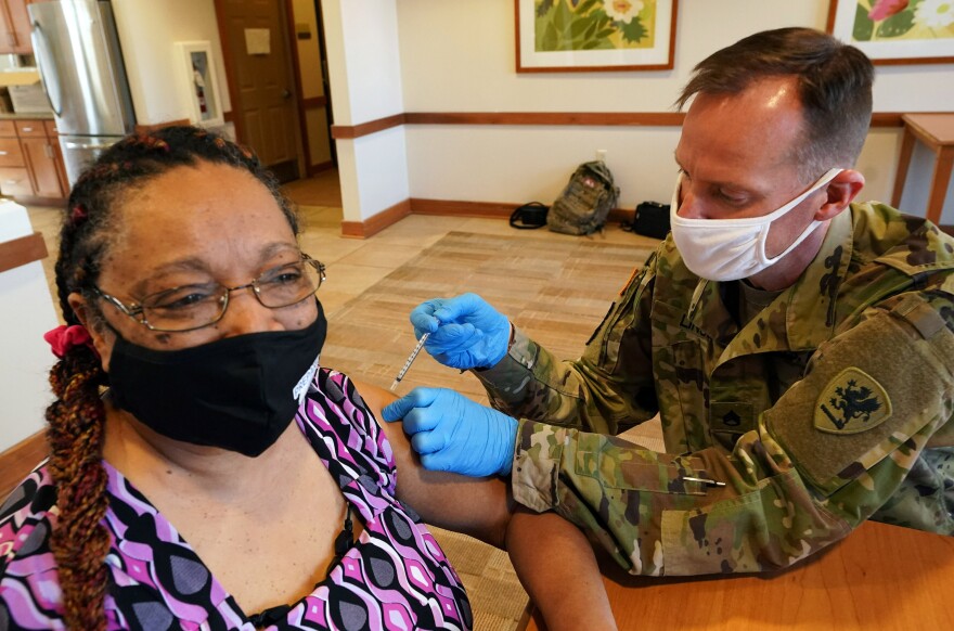 Patricia Bolden receives the Johnson & Johnson vaccine from Missouri National Guardsman Herbert Lin at Cambridge Senior Living Center in St. Louis on Thursday, March 4, 2021.                       