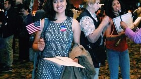 Maria Siliezar stands waves an American flag during after the citizenship ceremony.