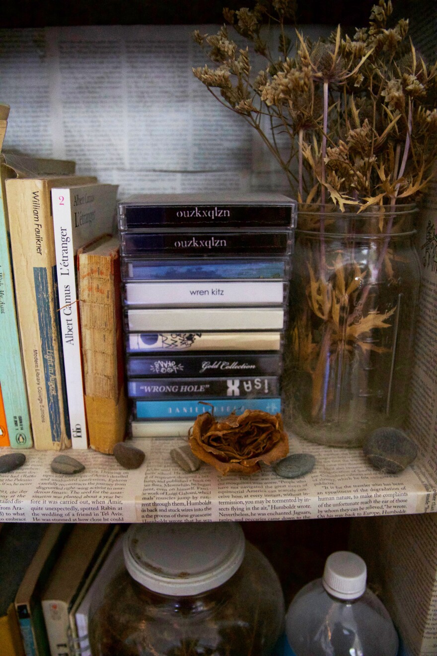 A stack of cassette tapes on a shelf. 