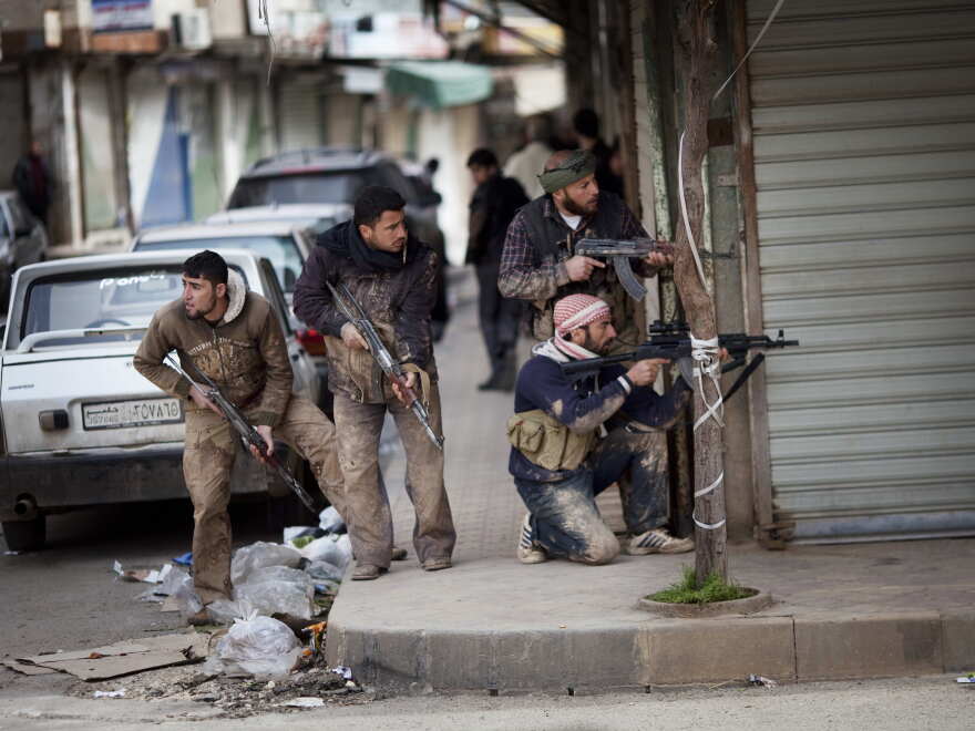 Syrian rebels take position during clashes with government forces in Idlib, north Syria.