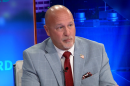 A man sitting at a desk on a news show.
