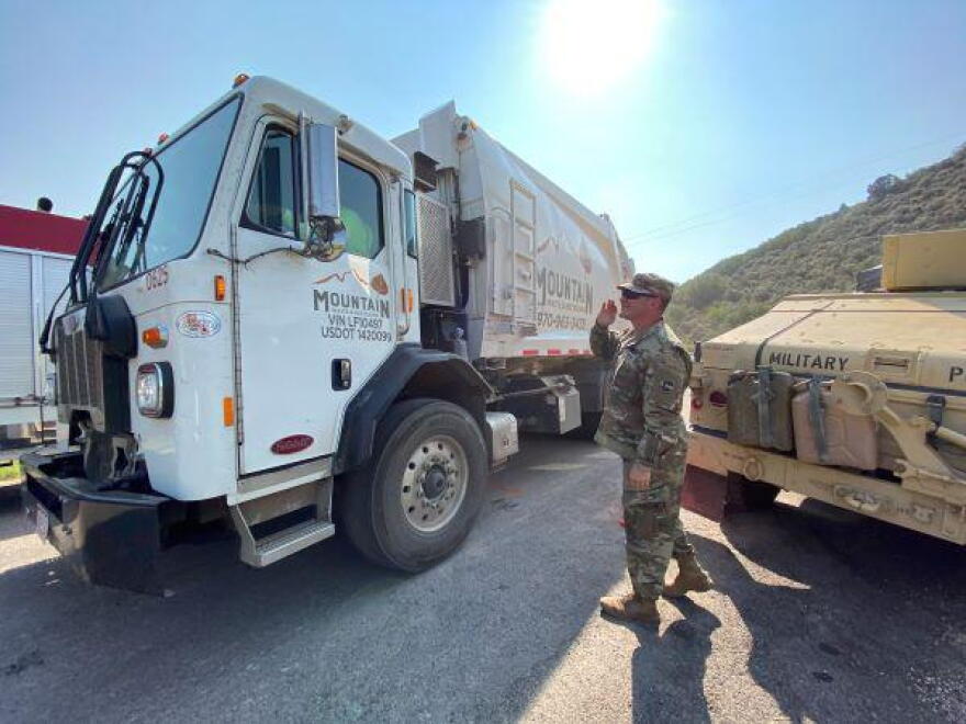 Sgt Kevin Duke of CO Nat'l Guard gives the go-ahead to a local trash truck on Upper Cattle Creek Rd.