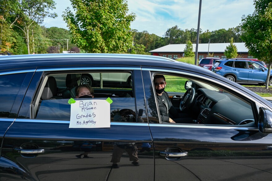 Brian McGovern and his mom, Liza, wait at the parent drop off circle to unload. Many parents drove so their children could avoid the bus ride. Prospect Elementary School designated specific entrances for each grade to avoid further points of contact. Stud