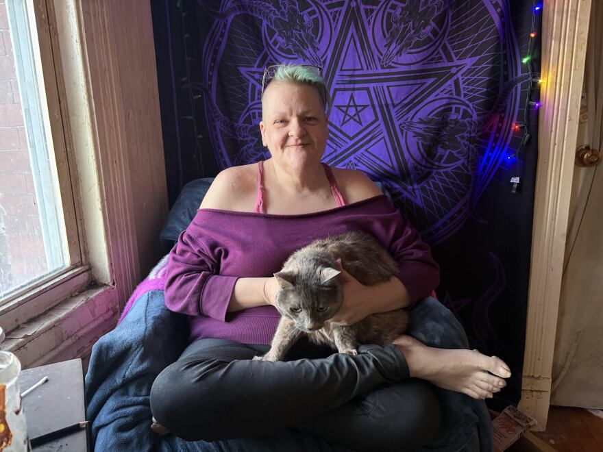 Kelly Verrier and her cat Henri at their New Haven home. Verrier is food insecure and says feeding Henri often takes precedence over feeding herself.
