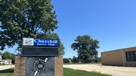  The sign outside the former Churchill Junior High School building in Galesburg, with tall oak trees behind it. 