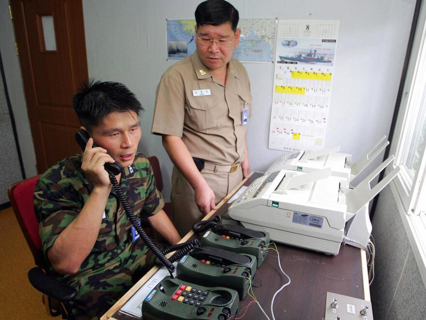 South Korean Lt. Choi Don-rim (left) communicates via a hotline with a North Korean officer at a military office near the Demilitarized Zone in 2005. Pyongyang has announced that it would re-establish a long-closed border hotline.