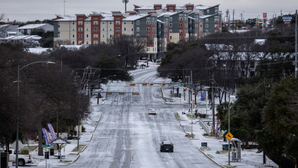 A couple vehicles travel down a hilly and icy section of Oltorf Street on Sunday, Jan. 25, 2026, in the East Riverside neighborhood of Austin, Texas. Overnight the region saw freezing rain and sleet, leading to up to one-quarter inch of ice in much of the area. Michael Minasi/KUT News
